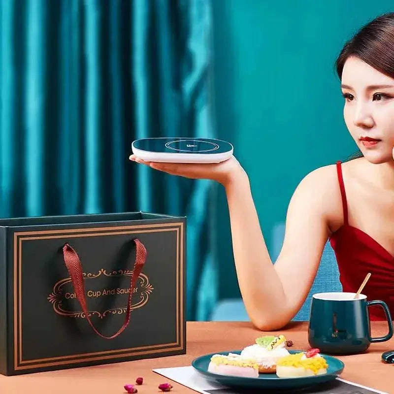 A ceramic mug steaming gently on the electric heating plate of the coffee warmer.